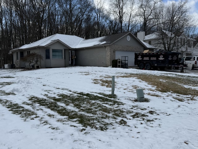 view of front of property featuring a chimney and an attached garage