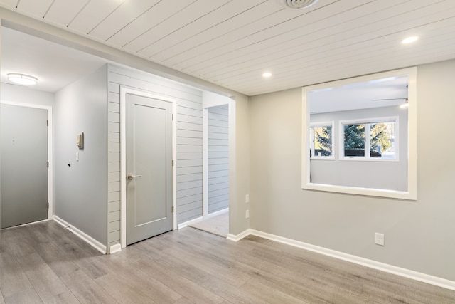 spare room with wood ceiling and light wood-type flooring