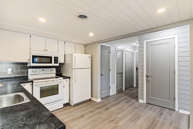 kitchen with tasteful backsplash, sink, white cabinets, white appliances, and light wood-type flooring