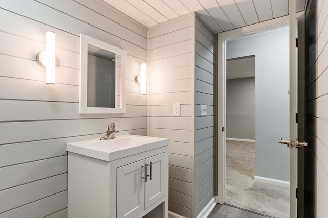 bathroom with vanity and wood walls