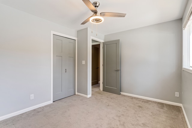 unfurnished bedroom featuring light carpet, a closet, and ceiling fan