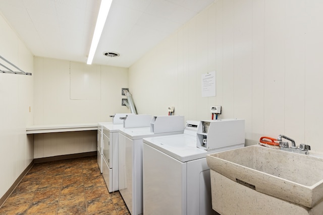 clothes washing area with washer and clothes dryer and sink