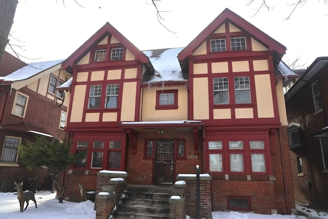 tudor house featuring brick siding and stucco siding