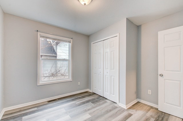 unfurnished bedroom with a closet and light hardwood / wood-style flooring