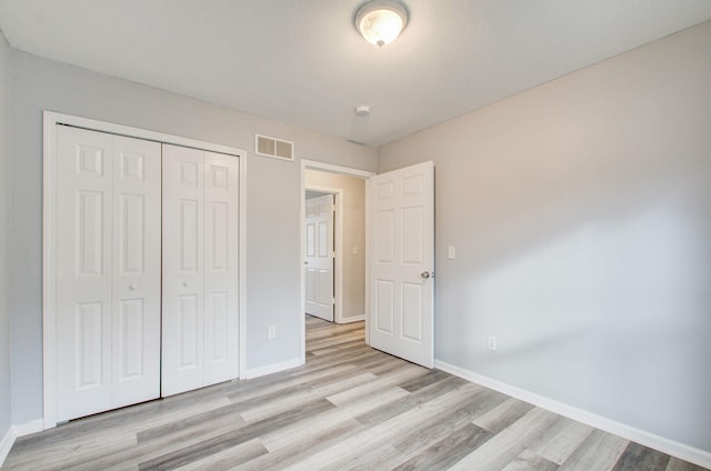 unfurnished bedroom featuring light wood-type flooring and a closet