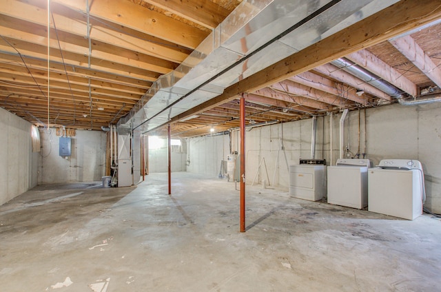 basement featuring washing machine and clothes dryer and electric panel