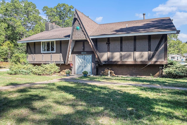 rear view of house featuring a yard and a sunroom