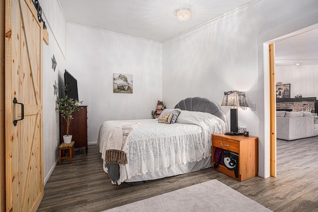 bedroom featuring hardwood / wood-style flooring and a barn door