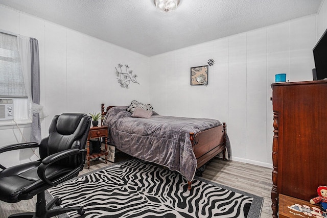 bedroom with light hardwood / wood-style floors and a textured ceiling