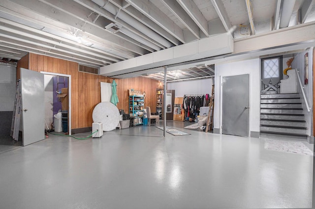 basement featuring wooden walls