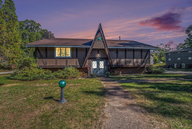 view of front of house featuring a sunroom and a lawn