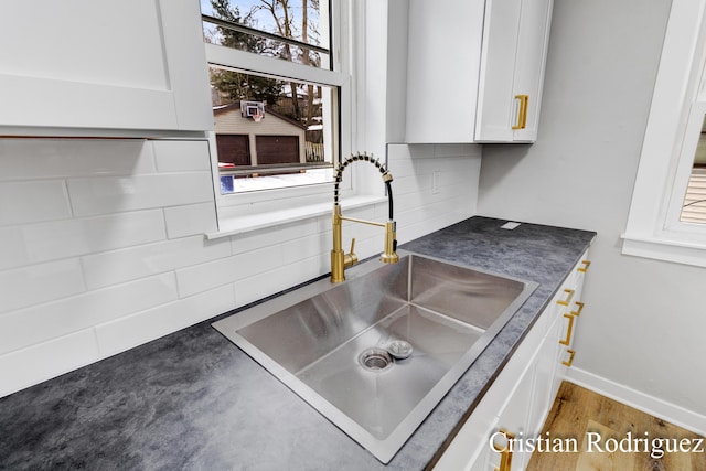 room details with hardwood / wood-style flooring, white cabinetry, and sink