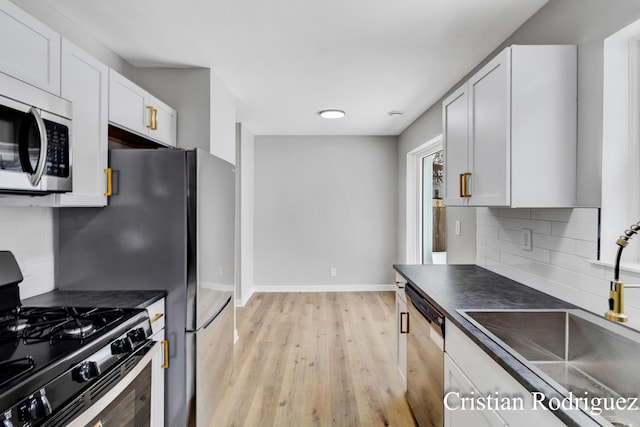 kitchen featuring stainless steel appliances, sink, and white cabinets