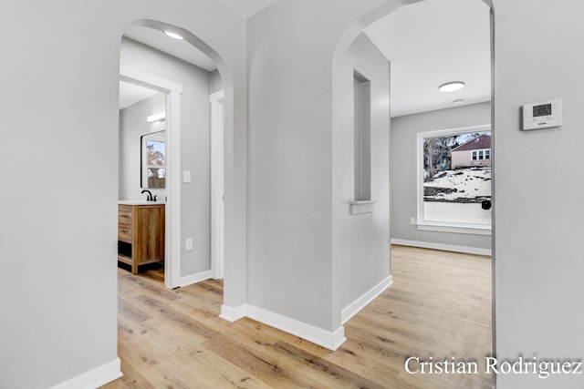 hallway with hardwood / wood-style flooring and sink