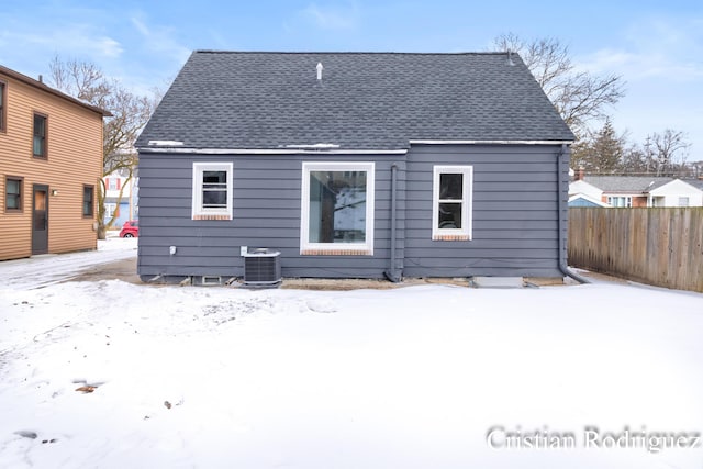 snow covered house featuring central AC