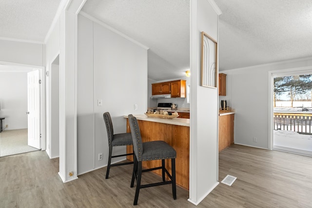 kitchen featuring ornamental molding, a breakfast bar, and kitchen peninsula