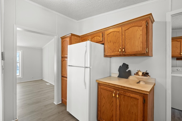 kitchen with crown molding, white fridge, and a textured ceiling