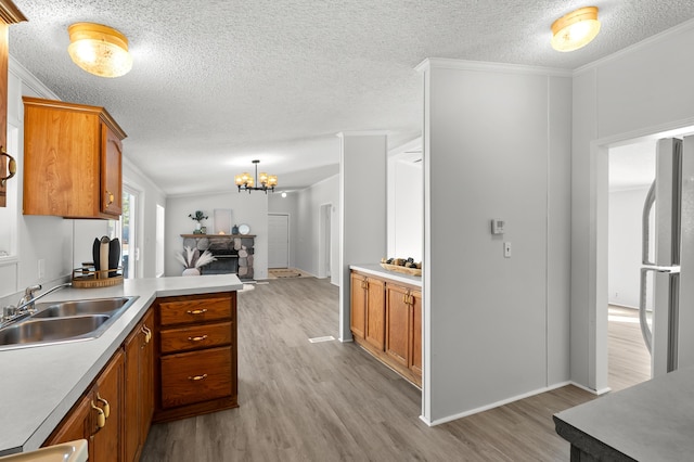 kitchen featuring crown molding, sink, stainless steel refrigerator, and light wood-type flooring