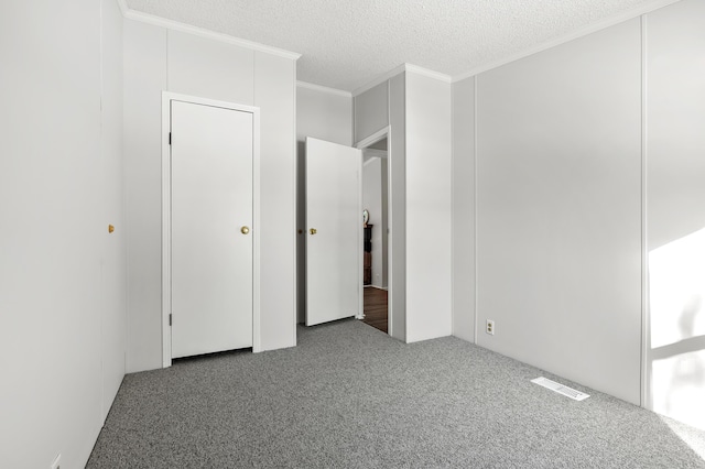 unfurnished bedroom with ornamental molding, carpet, and a textured ceiling