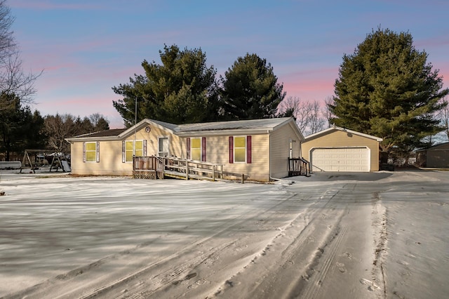 view of front of house with a garage and an outbuilding