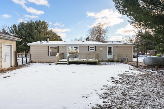 snow covered rear of property featuring a wooden deck