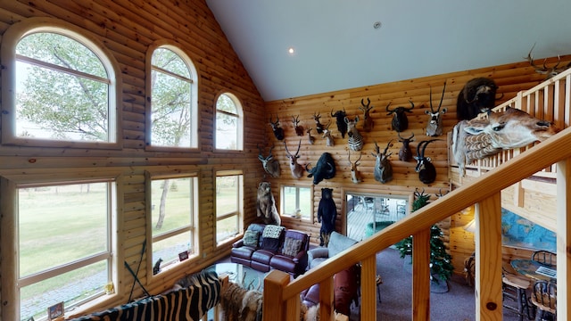 living area with high vaulted ceiling and rustic walls