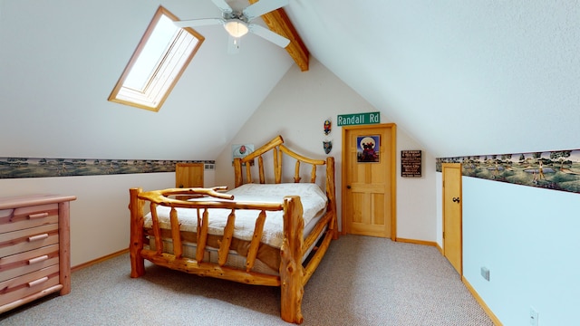 carpeted bedroom featuring lofted ceiling with skylight, ceiling fan, and baseboards