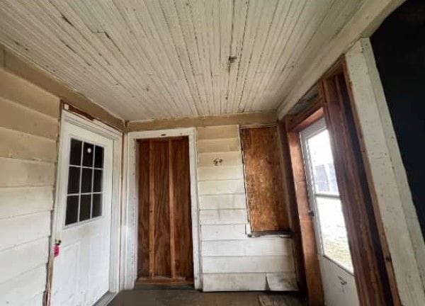 interior space featuring wood ceiling and wooden walls