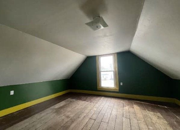 additional living space with wood-type flooring and lofted ceiling