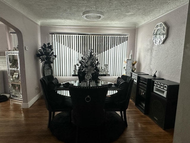 dining area featuring ornamental molding, dark hardwood / wood-style flooring, and a textured ceiling