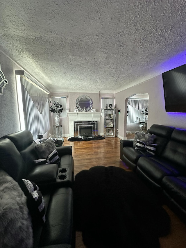 living room featuring wood-type flooring, a textured ceiling, and a wealth of natural light