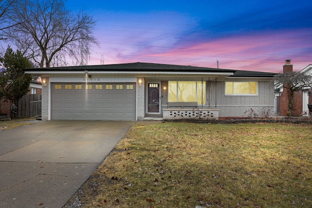 view of front of property featuring a garage and a lawn