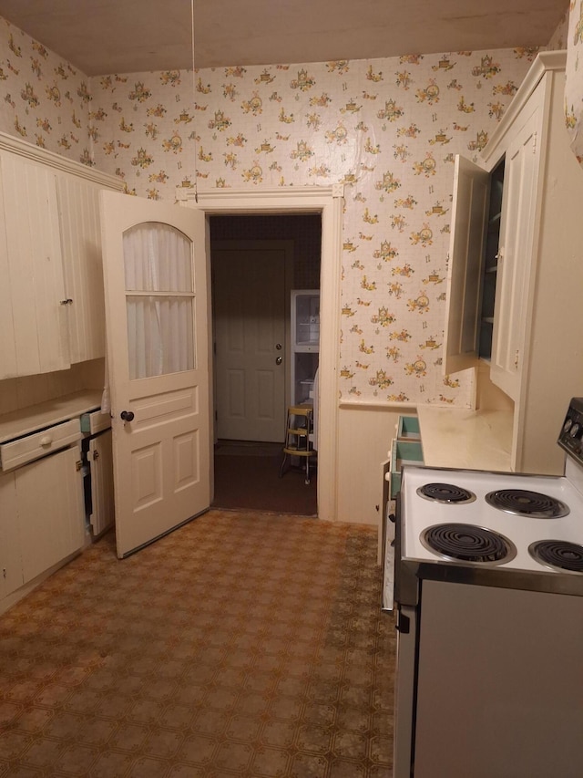 kitchen featuring electric range oven and white cabinets