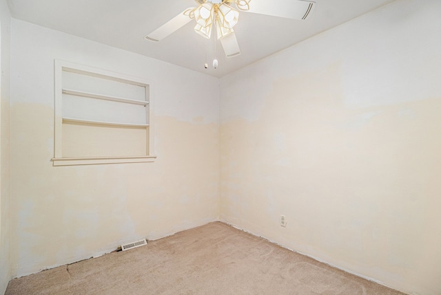 unfurnished room with light colored carpet and ceiling fan