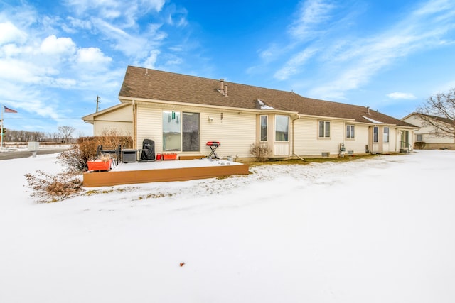 view of snow covered back of property