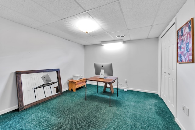 carpeted office space featuring a paneled ceiling