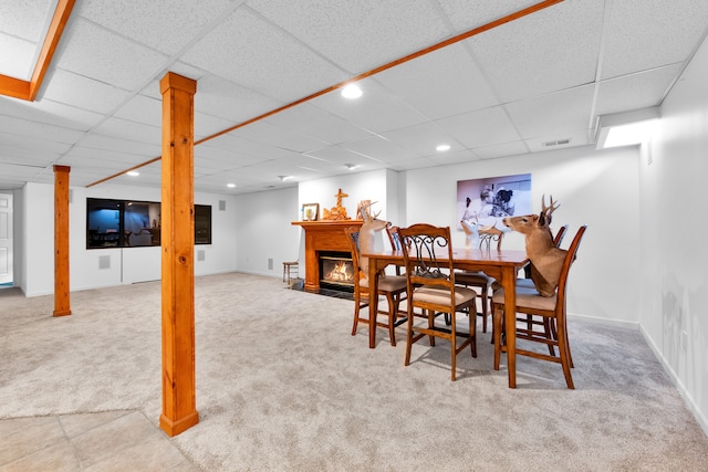 carpeted dining room with a paneled ceiling and decorative columns