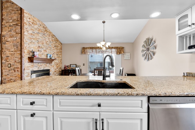 kitchen featuring sink, vaulted ceiling, stainless steel dishwasher, light stone countertops, and white cabinets