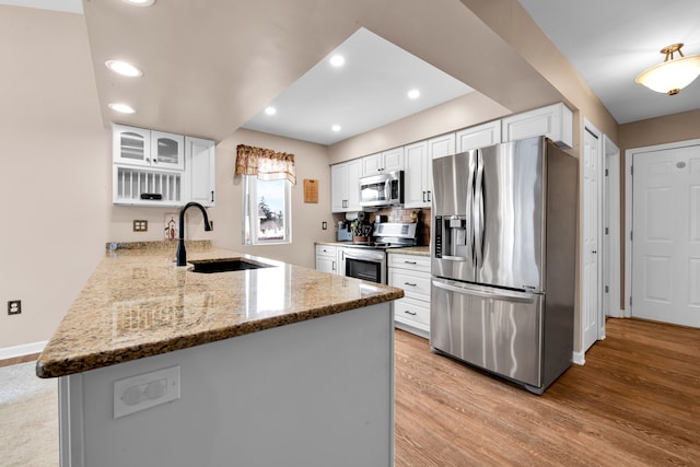 kitchen featuring white cabinetry, stainless steel appliances, and kitchen peninsula