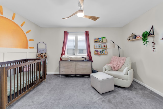 bedroom with a crib, ceiling fan, and carpet flooring