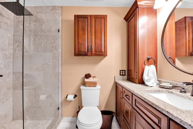 bathroom with tiled shower, vanity, toilet, and tile patterned flooring