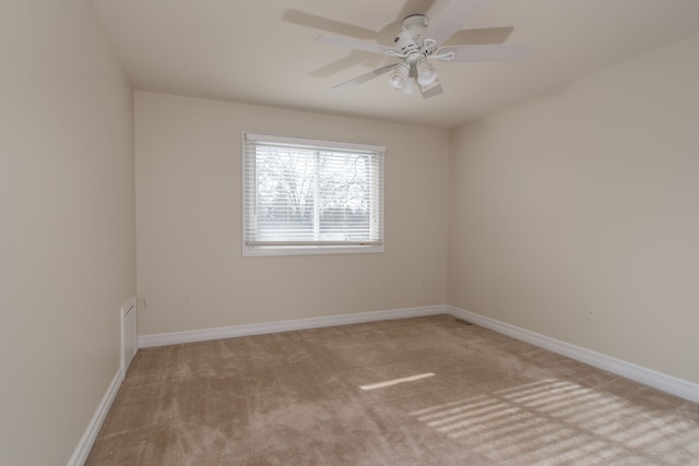 carpeted spare room featuring ceiling fan