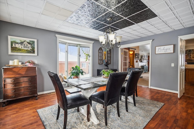 dining space featuring an inviting chandelier and dark hardwood / wood-style flooring