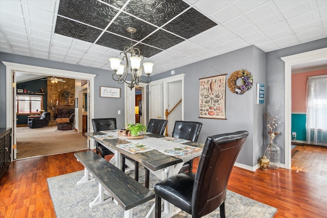 dining room with hardwood / wood-style flooring and ceiling fan with notable chandelier