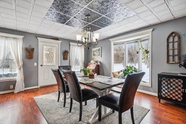 dining room featuring dark hardwood / wood-style floors, a healthy amount of sunlight, and an inviting chandelier