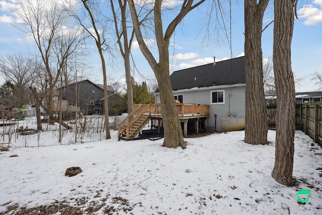 snow covered house featuring a wooden deck