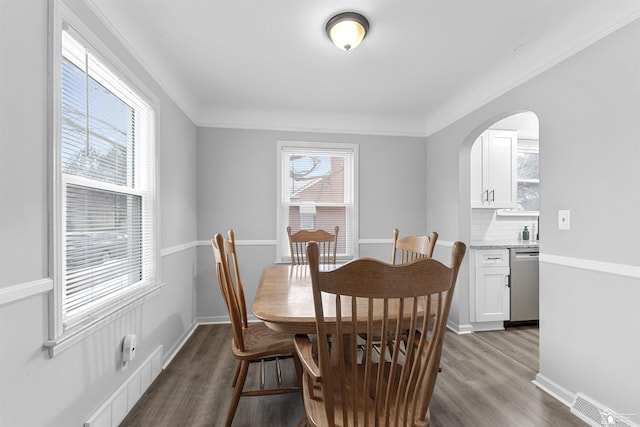 dining area with crown molding and hardwood / wood-style floors