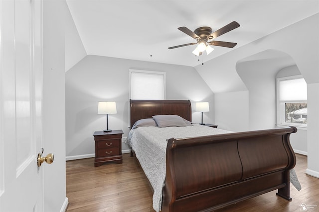 bedroom with dark hardwood / wood-style flooring, vaulted ceiling, and ceiling fan