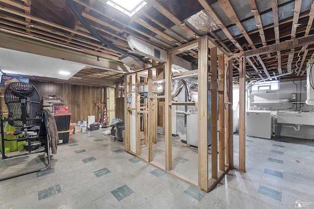 basement featuring washer / clothes dryer, sink, heating unit, and wooden walls