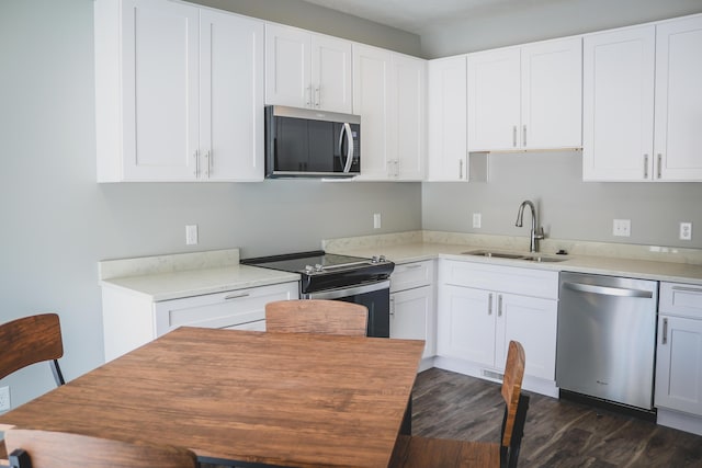 kitchen featuring stainless steel appliances, dark hardwood / wood-style flooring, sink, and white cabinets